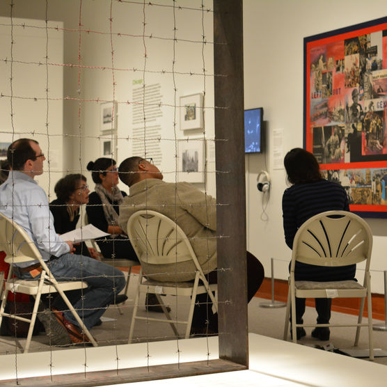 People in folding chairs studying work of art 